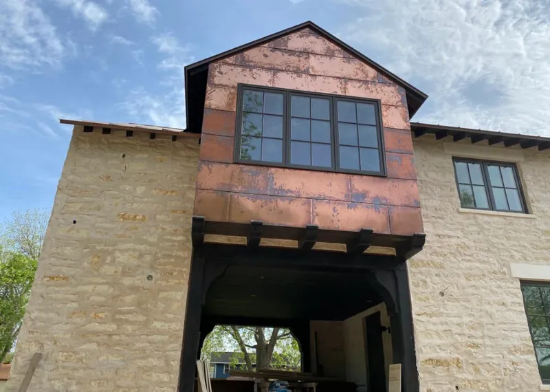 Copper metal panel facade on a stone building for Roof Repair in Willow Springs